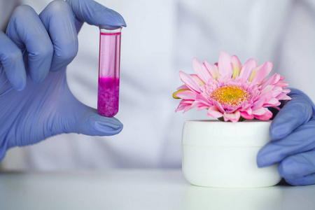 科学家正在做她的研究。化学实验。劳动者检验面部化妆品。科学家在实验室里用液体控制试管